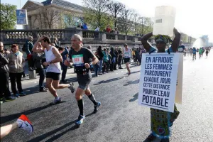 Mujer africana corre el Maratón de París con un bidón sobre la cabeza