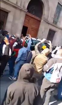 Normalistas de Ayotzinapa derriban puerta de Palacio Nacional en plena mañanera de AMLO
