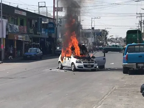 En enfrentamiento con policías, comerciantes de San Francisco Totimehuacan  queman coche