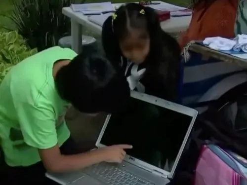 Donan laptop a hermanitos que toman clases en la calle