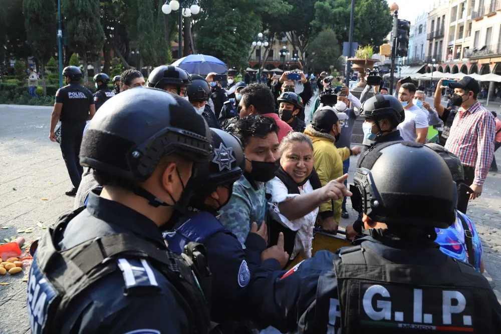 Ambulantes enfrentan a policías por desalojo en el zócalo de Puebla