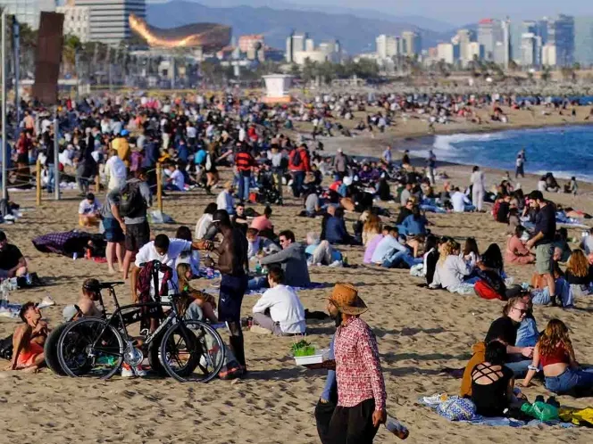 Sin cubrebocas turistas desafían al Covid-19 en playa de Barcelona