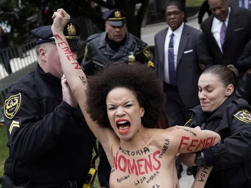 Manifestante “topless” encara a Bill Cosby al empezar su juicio
