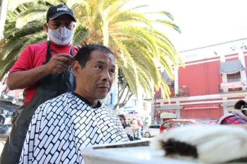 Estilistas de escuelas de corte ofrecen servicio social en la calle 5 de mayo