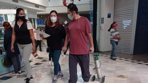 Indigna foto de hombre caminando con su tanque de oxígeno en una plaza comercial