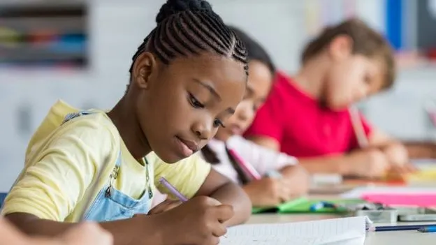 Una niÃ±a en un escritorio de una escuela.