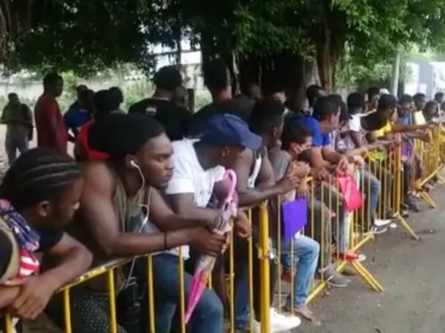 Migrantes ignoran sana distancia y se aglomeran en oficina del INM