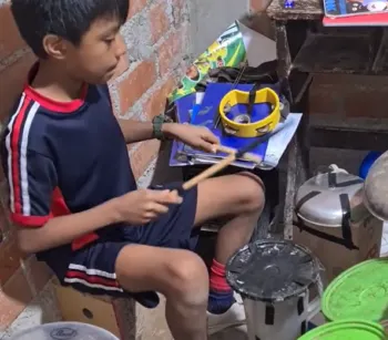 Niño toca una batería hecha a mano