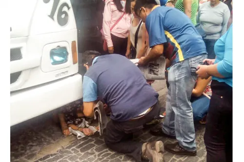Mujer de la tercera edad queda debajo de transporte público