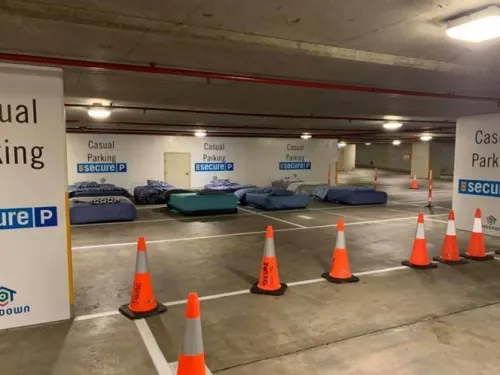 En este estacionamiento ponen camas por las noches para los indigentes