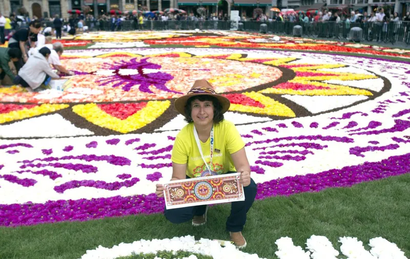 La mexicana Ana Rosa Aguilar Aguado, también conocida como Roo, posa sobre la alfombra de flores que ha diseñado para cubrir la Grand Place de Bruselas.